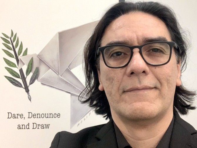 Pedro X. Molina in front of his artwork, "Dare, denounce, and draw."
