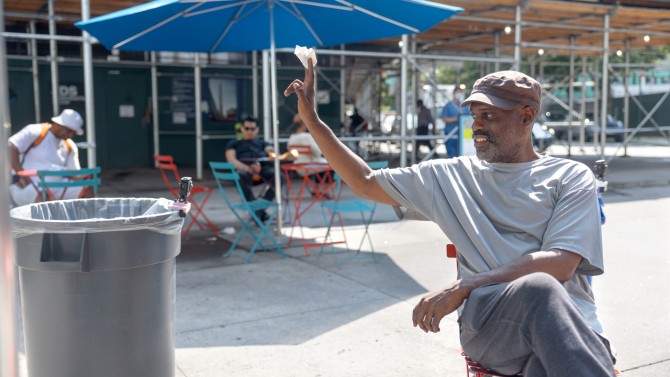 A man prepares to deposit trash into one of the trashbots during deployment in Albee Square, Brooklyn, in July. 