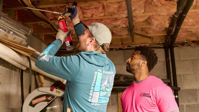 Trainees from the Energy Warriors program gain hands-on experience insulating basements.
