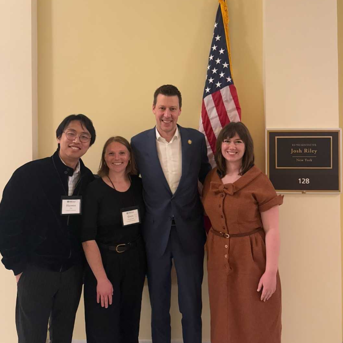 Doctoral students Haowen Hu, Gwyneth Frederick, and Marjorie Hanneman with Representative Josh Riley