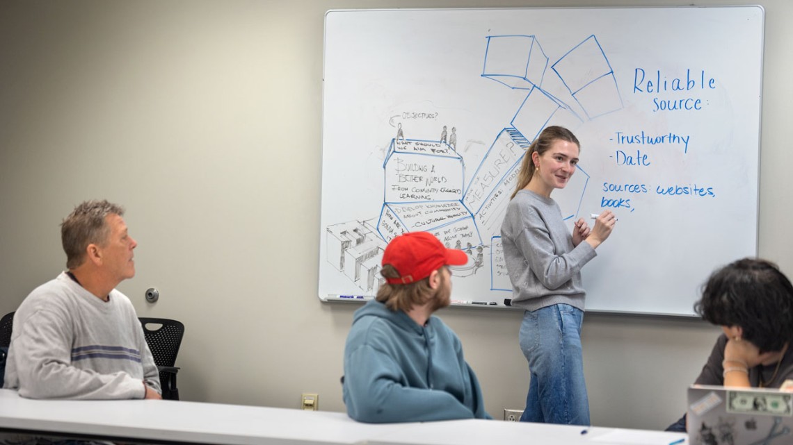 Isabelle Erskine '25, president of the TST-BOCES Career Skills Club, leads a discussion with a group of TST-BOCES students with intellectual disabilities and their teachers on March 17 in Kennedy Hall.